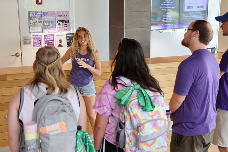 A student tour guide giving an explanation of a lobby space to students