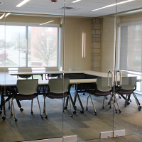 Tables and chairs are in a conference room setup.