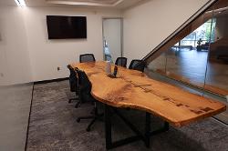 A conference room with a large, wooden conference table and moveable chairs.