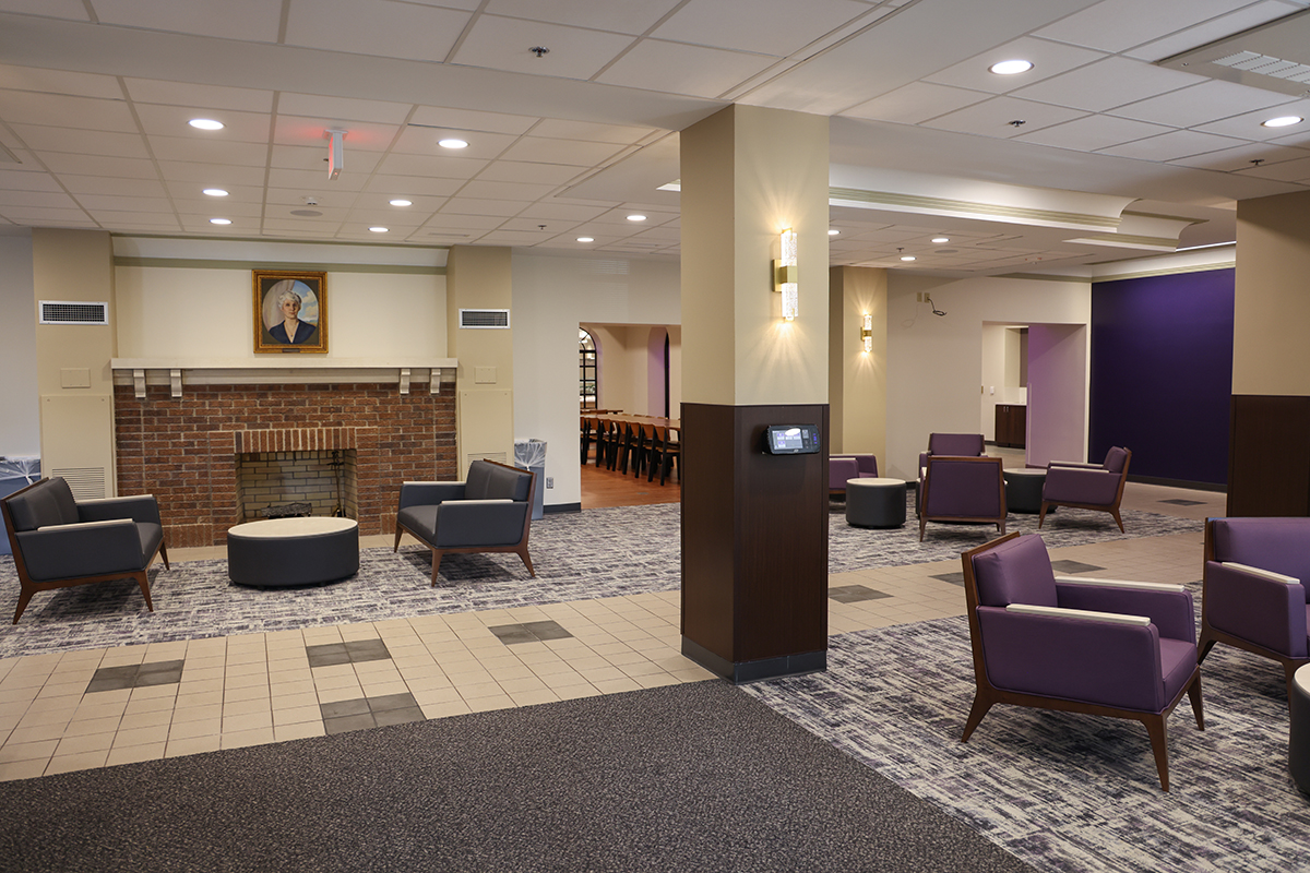 Lobby of Van Zile Hall with comfortable seating and tables in front of a fireplace