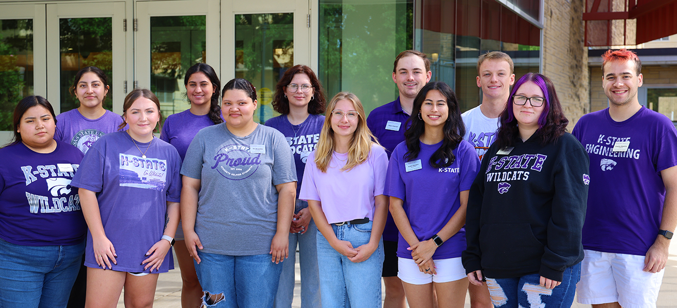A group of K-State undergraduate students standing in front of the entrance to Derby Dining Center