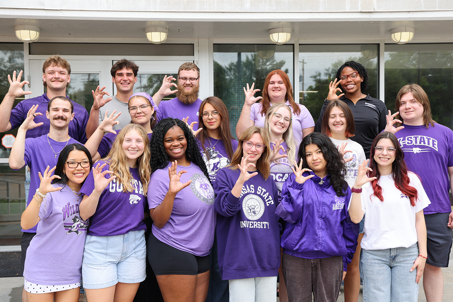 A group of K-State students standing in front of the entrance of Marlatt Hall.