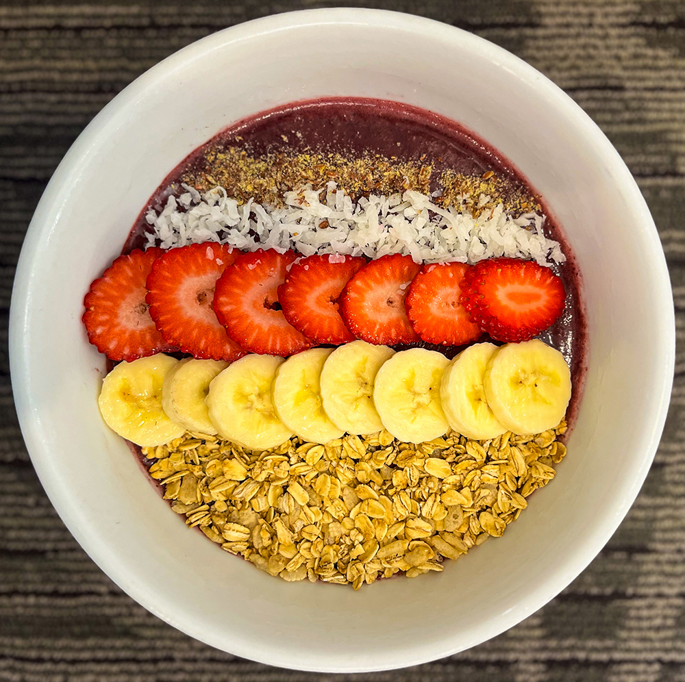 Açai bowl topped with coconut, strawberries, bananas and granola